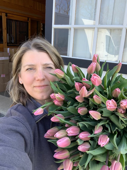 Owner Sharon Hays with armful of early spring pink tulips